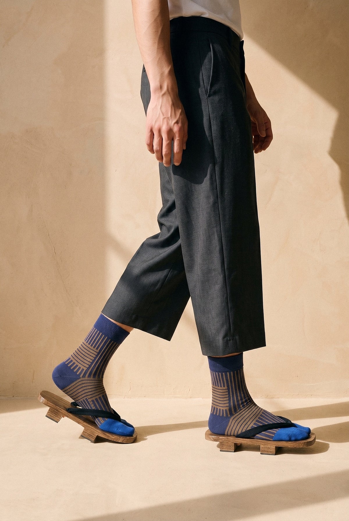 Calcetines tabi Sen, rayas, azul: modelo caminando, en estudio, pared de cal ocre