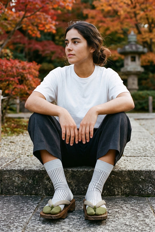Calcetines tabi Sen, rayas, gris claro: modelo sentada en un escalón, en un jardín japonés en otoño con arces rojos