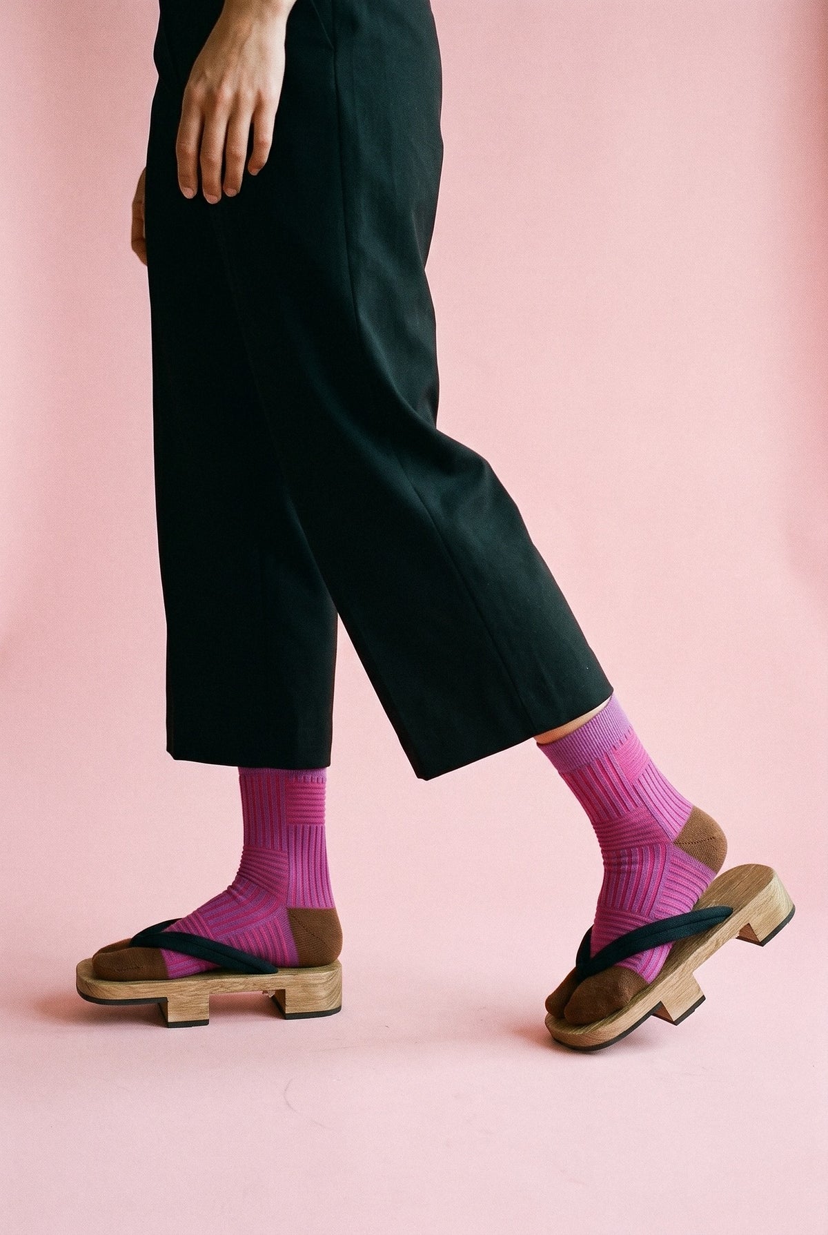 Calcetines tabi Sen, rayas, rosa fucsia: modelo caminando, en estudio, fondo rosa empolvado con peana blanca