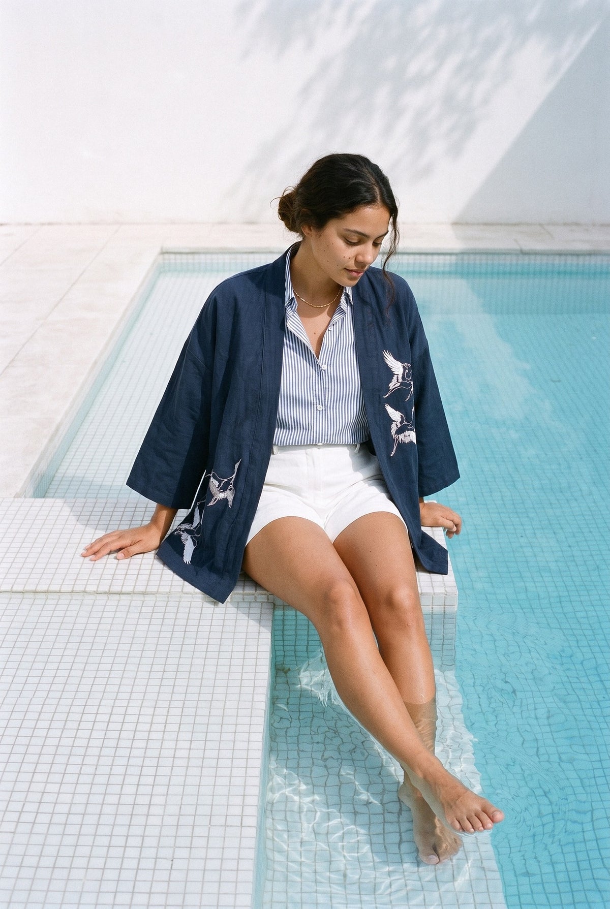 Haori Kaze azul marino, sentada en el borde de la piscina