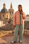 Chaqueta acolchada Benihana, flores, rosa salmón: vista de frente, en una azotea de Valencia con vistas a las cúpulas