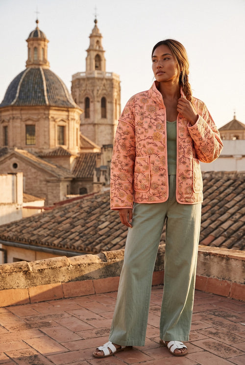 Chaqueta acolchada Benihana, flores, rosa salmón: vista de frente, en una azotea de Valencia con vistas a las cúpulas