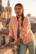 Chaqueta acolchada Benihana, flores, rosa salmón: modelo apoyada en un muro, en una azotea de Valencia con vistas a las cúpulas