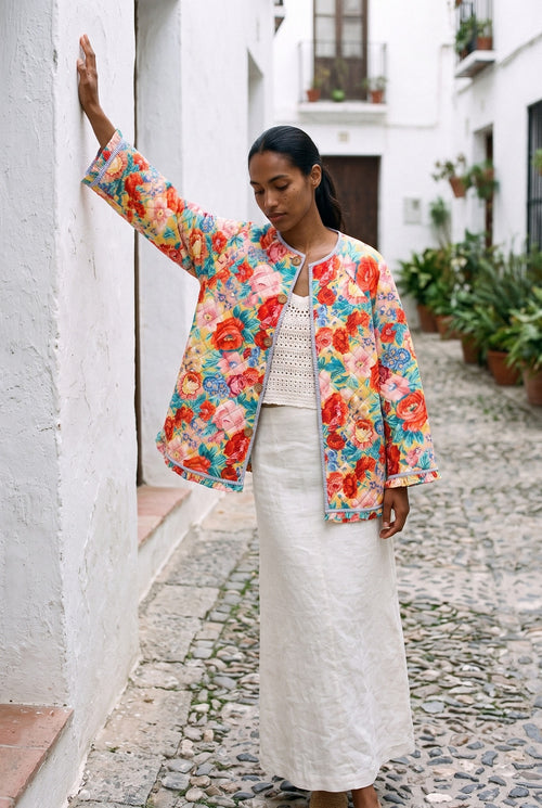 Chaqueta acolchada Hanabatake, flores a todo color: modelo con un brazo en alto, en una calle empedrada del Albaicín