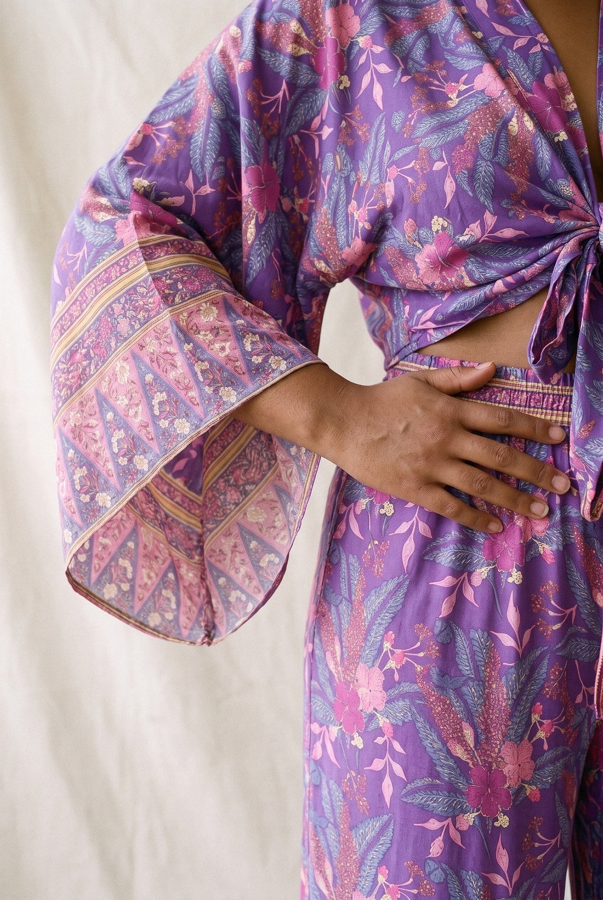 Conjunto kimono Murasaki, kimono corto y pantalón, morado: detalle de la manga y del estampado, en estudio, fondo de lienzo crudo