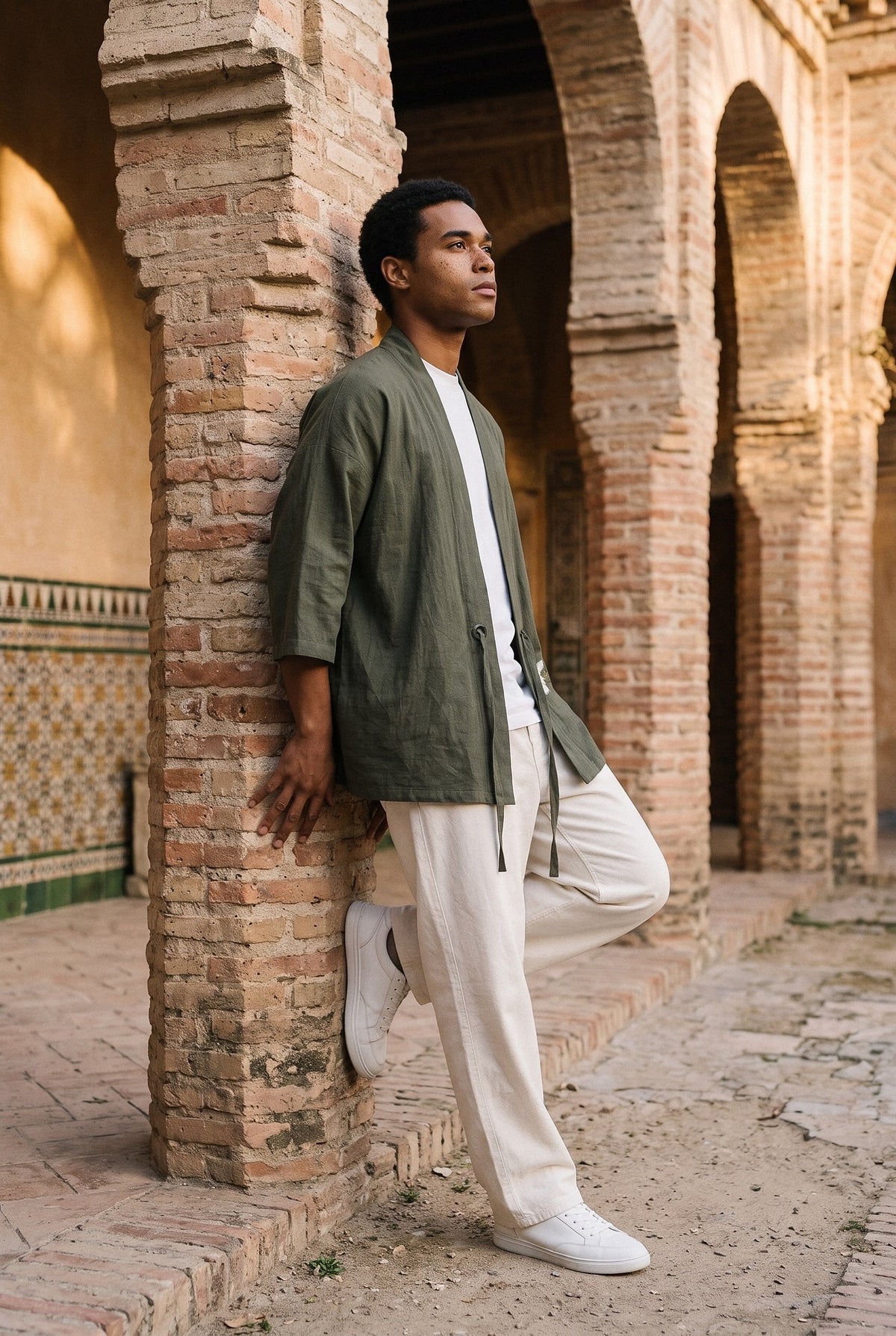 Haori Tsuru, grullas bordadas, verde oliva: modelo apoyado en la pared, en el patio mudéjar de un palacio de Toledo
