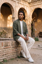 Haori Tsuru, grullas bordadas, verde oliva: modelo sentado de lado con las piernas cruzadas, en el patio mudéjar de un palacio de Toledo