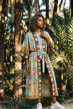Kimono largo Koke, pavo real y flores, verde salvia: vista de frente, en un palmeral de Elche