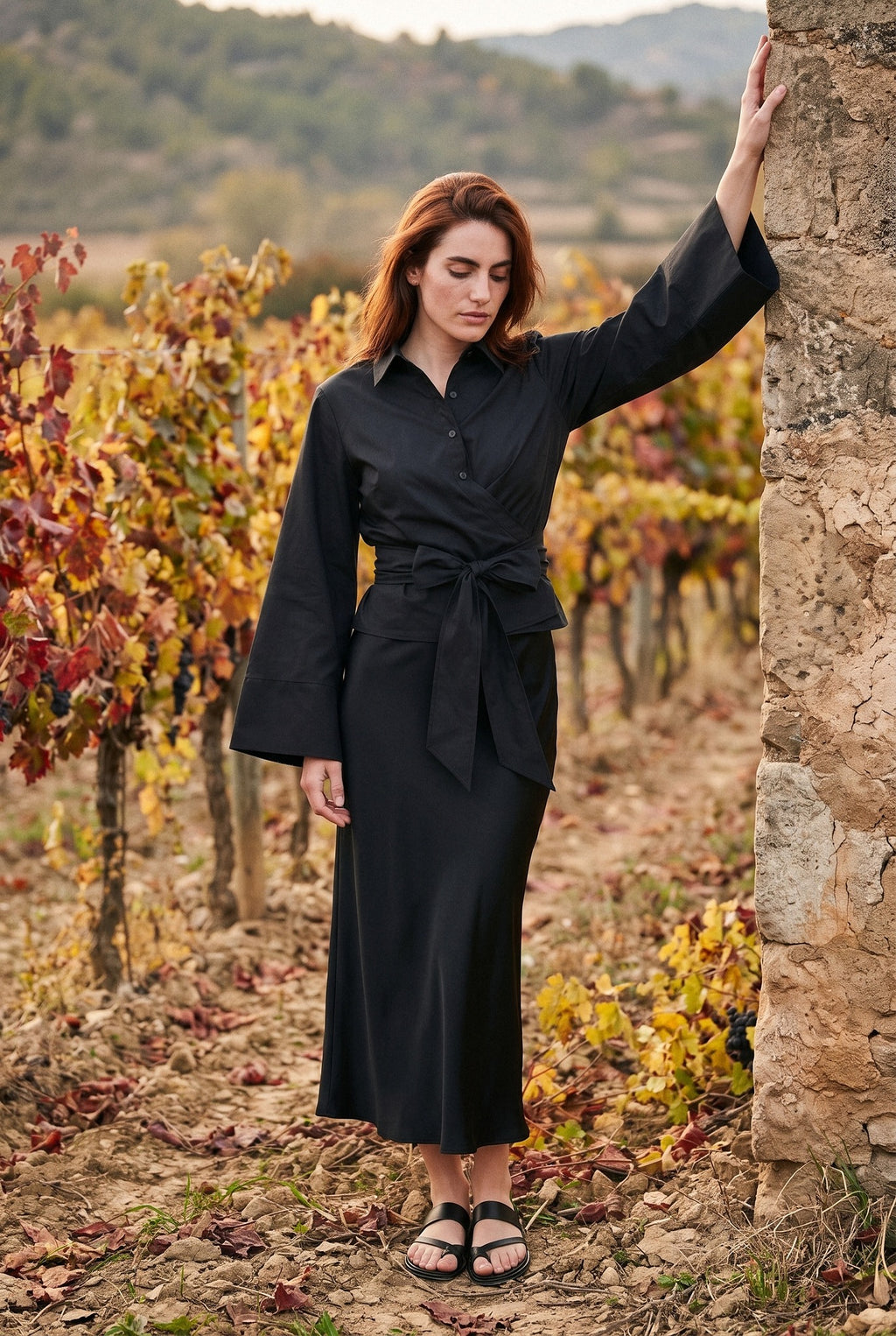 Kimono corto Musubi, blusa cruzada con lazo, negro: modelo con un brazo en alto, en un viñedo de La Rioja en otoño