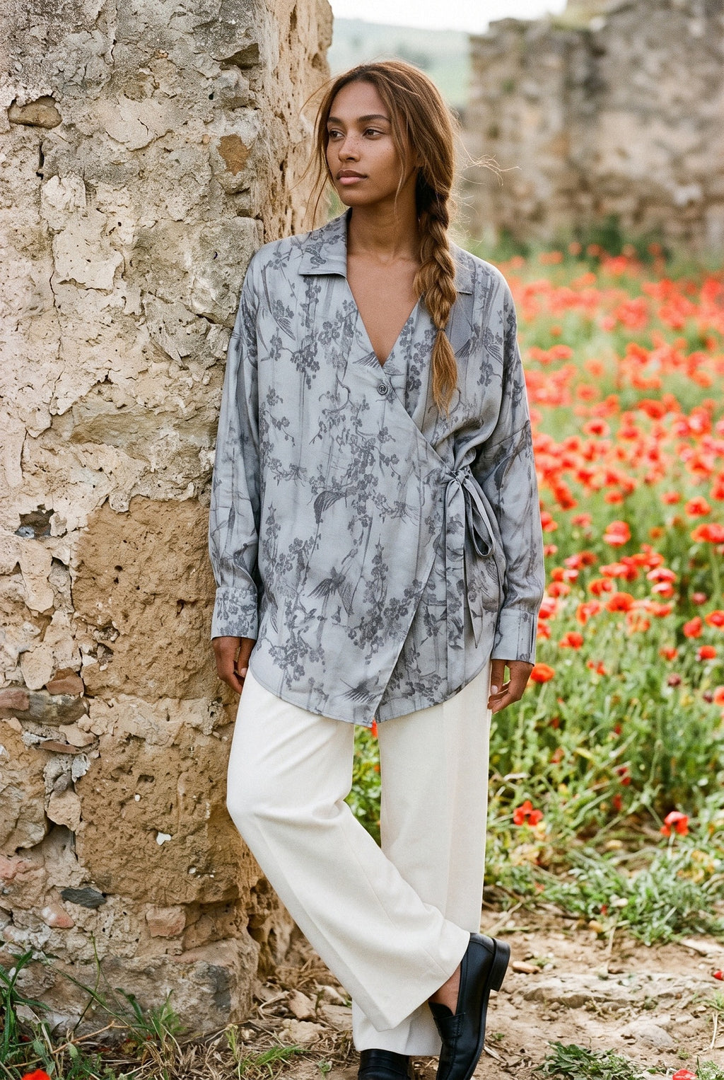 Camisa kimono Nezumi, ciruelo en flor y pájaros, gris: modelo apoyada en la pared, en un campo de amapolas de Andalucía