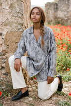Camisa kimono Nezumi, ciruelo en flor y pájaros, gris: modelo con una rodilla en el suelo, en un campo de amapolas de Andalucía