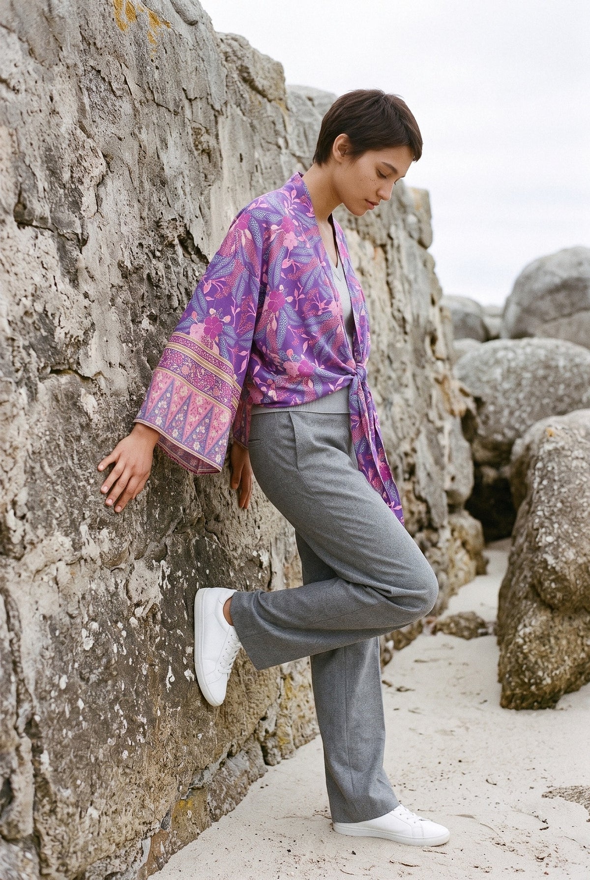 Kimono corto Shion, flores, violeta: modelo apoyada en la pared, en una playa gallega de rocas de granito