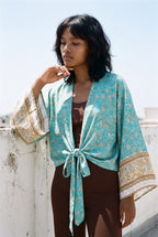 Kimono corto Wakaba, flores, turquesa: retrato, mano en la barbilla, en una azotea blanca de Cádiz