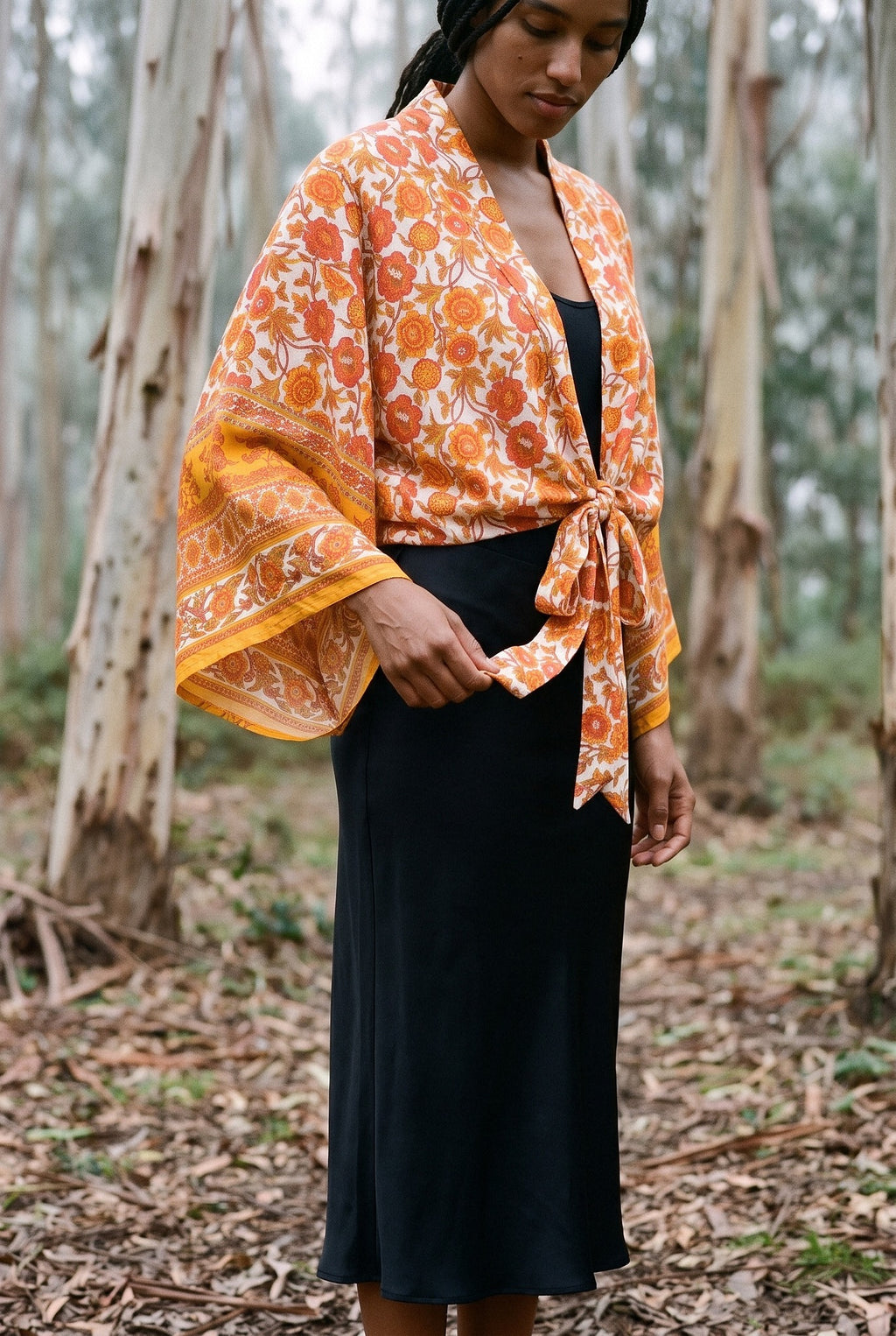 Kimono corto Yamabuki, flores, marfil y naranja: detalle del estampado y del tejido, en un bosque de eucaliptos de Cantabria