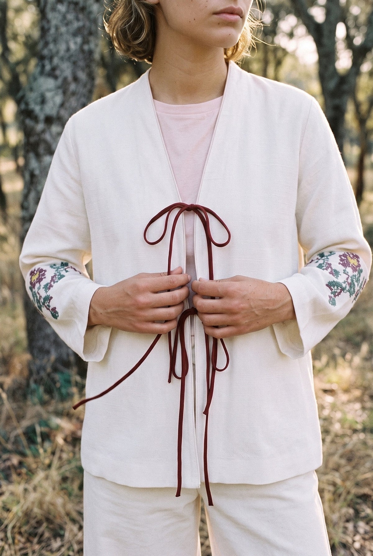 Kimono corto Yuri, bordado floral, crudo: detalle del bordado y del tejido, en un alcornocal de Extremadura