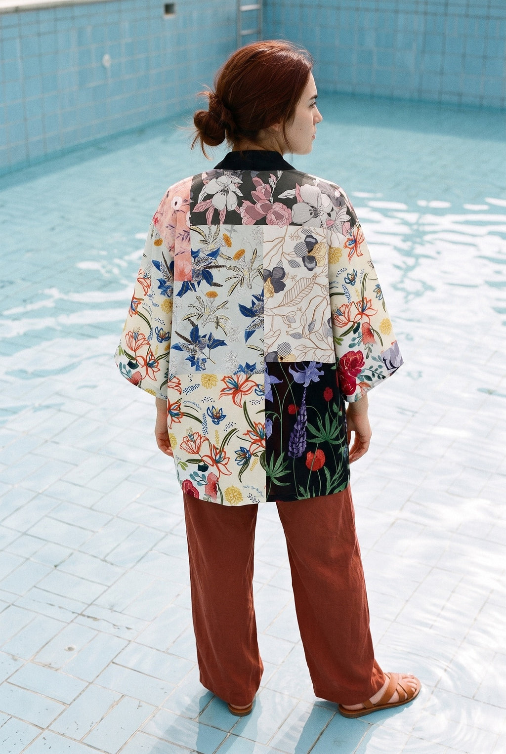 Kimono japonés Hanabi, patchwork floral, blanco: vista de espaldas, en una piscina municipal de azulejos azul pálido