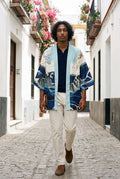 Kimono japonés Kanagawa, olas y remolino, azul: modelo caminando hacia la cámara, en un callejón de Sevilla con buganvillas