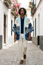 Kimono japonés Kanagawa, olas y remolino, azul: modelo caminando hacia la cámara, en un callejón de Sevilla con buganvillas