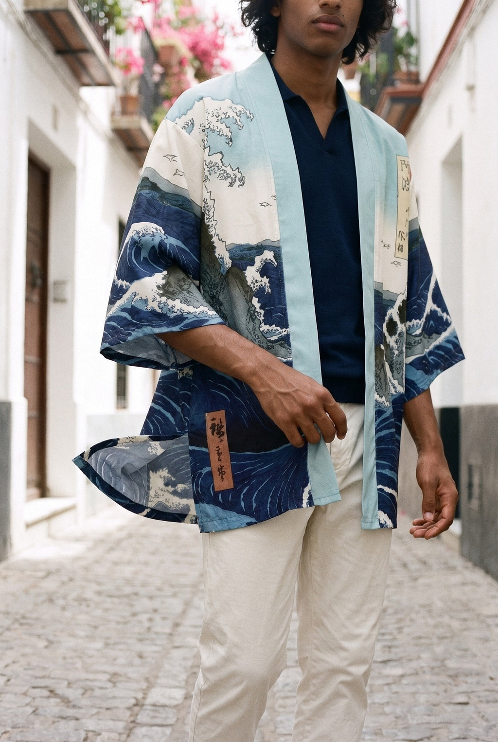 Kimono japonés Kanagawa, olas y remolino, azul: detalle del estampado y del tejido, en un callejón de Sevilla con buganvillas