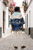 Kimono japonés Kanagawa, olas y remolino, azul: vista de espaldas, en un callejón de Sevilla con buganvillas