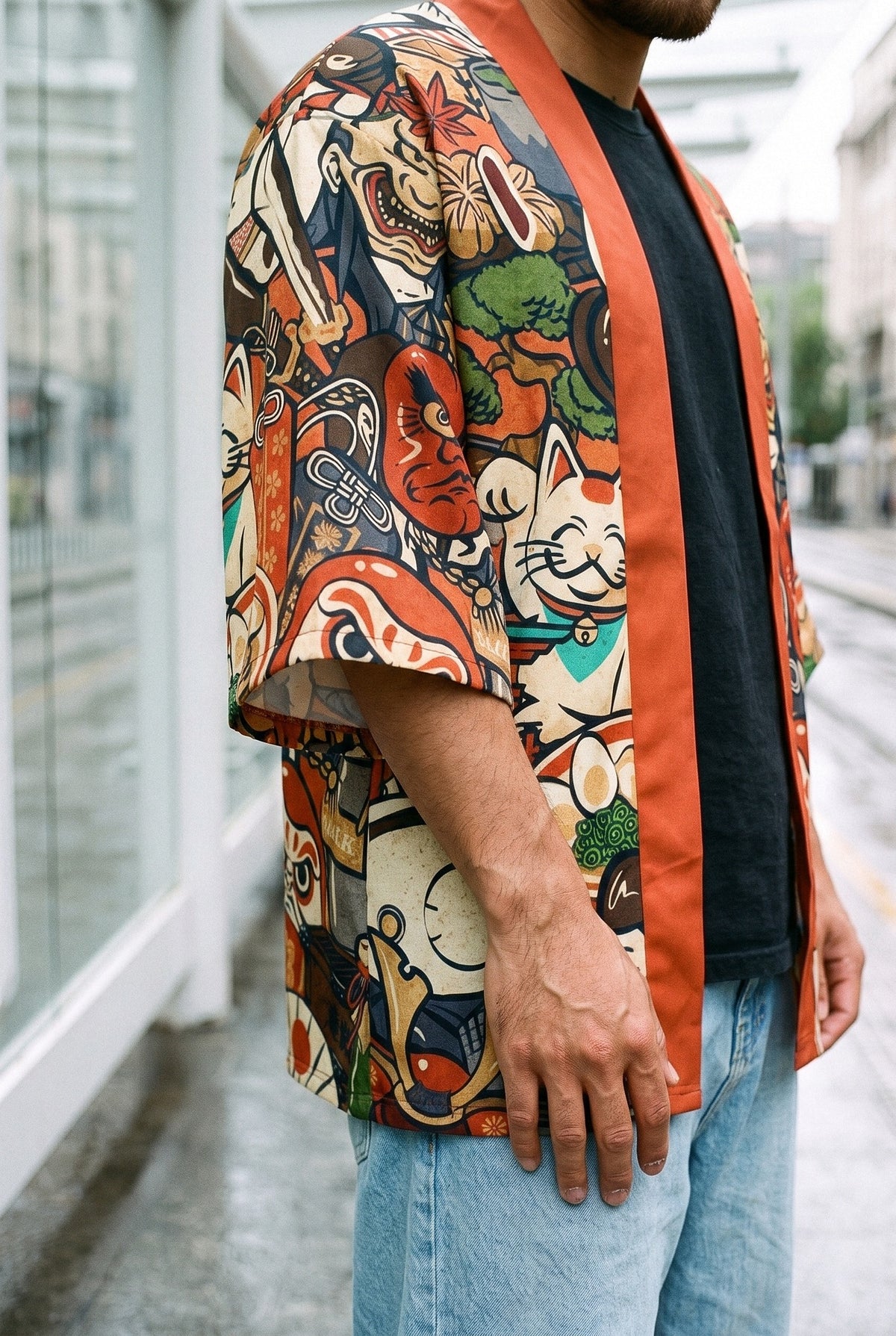 Kimono japonés Maneki, gato samurái, rojo: detalle de la manga y del estampado, en una parada de tranvía de Bilbao