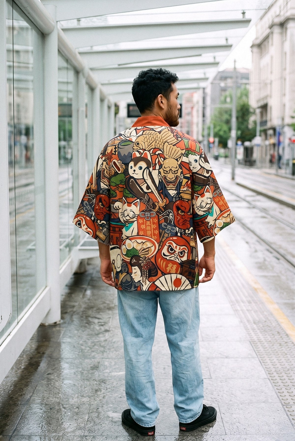 Kimono japonés Maneki, gato samurái, rojo: vista de espaldas, en una parada de tranvía de Bilbao