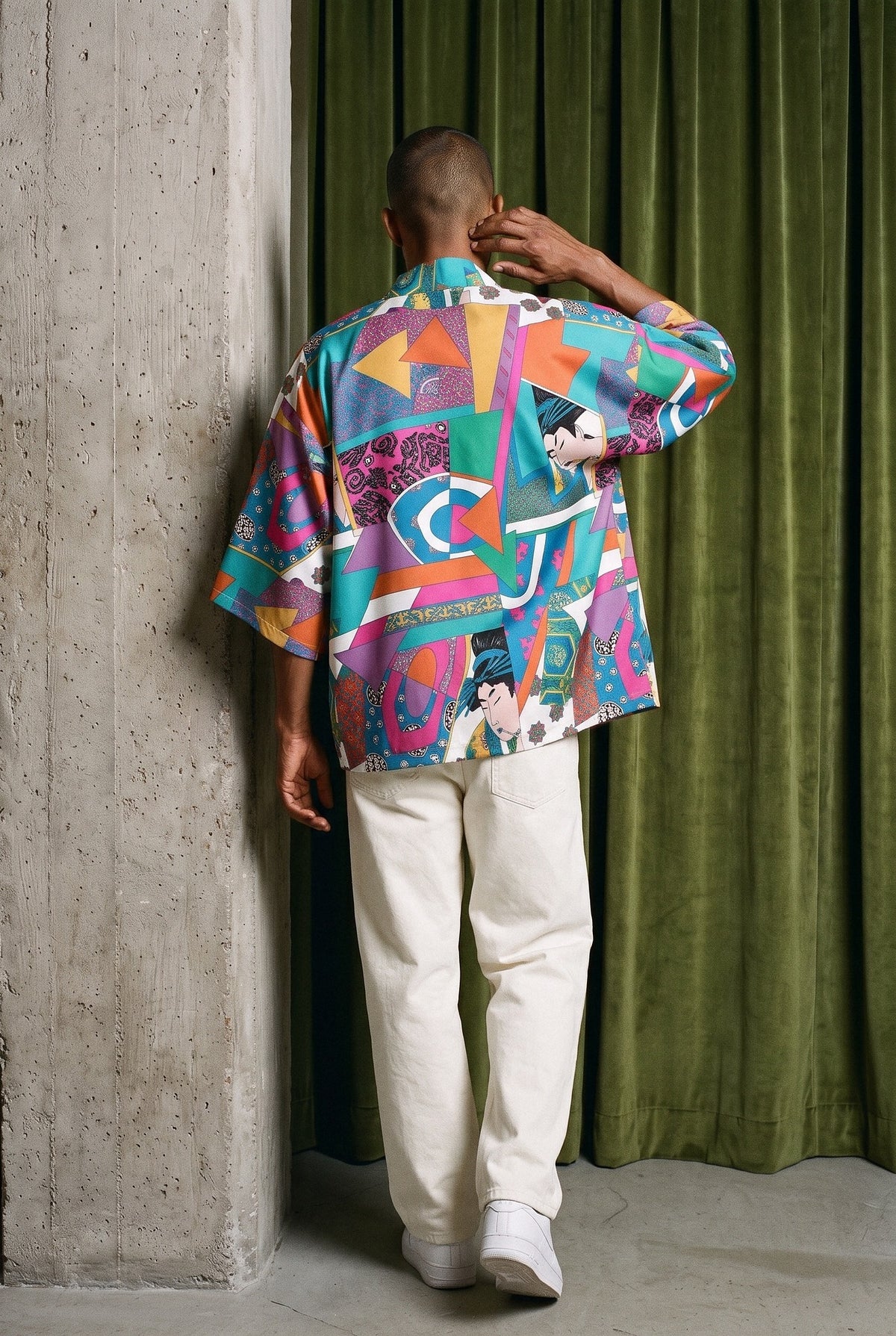 Kimono japonés Shibuya, patchwork de color: modelo de espaldas, alejándose despacio, en estudio, cortina de terciopelo verde musgo