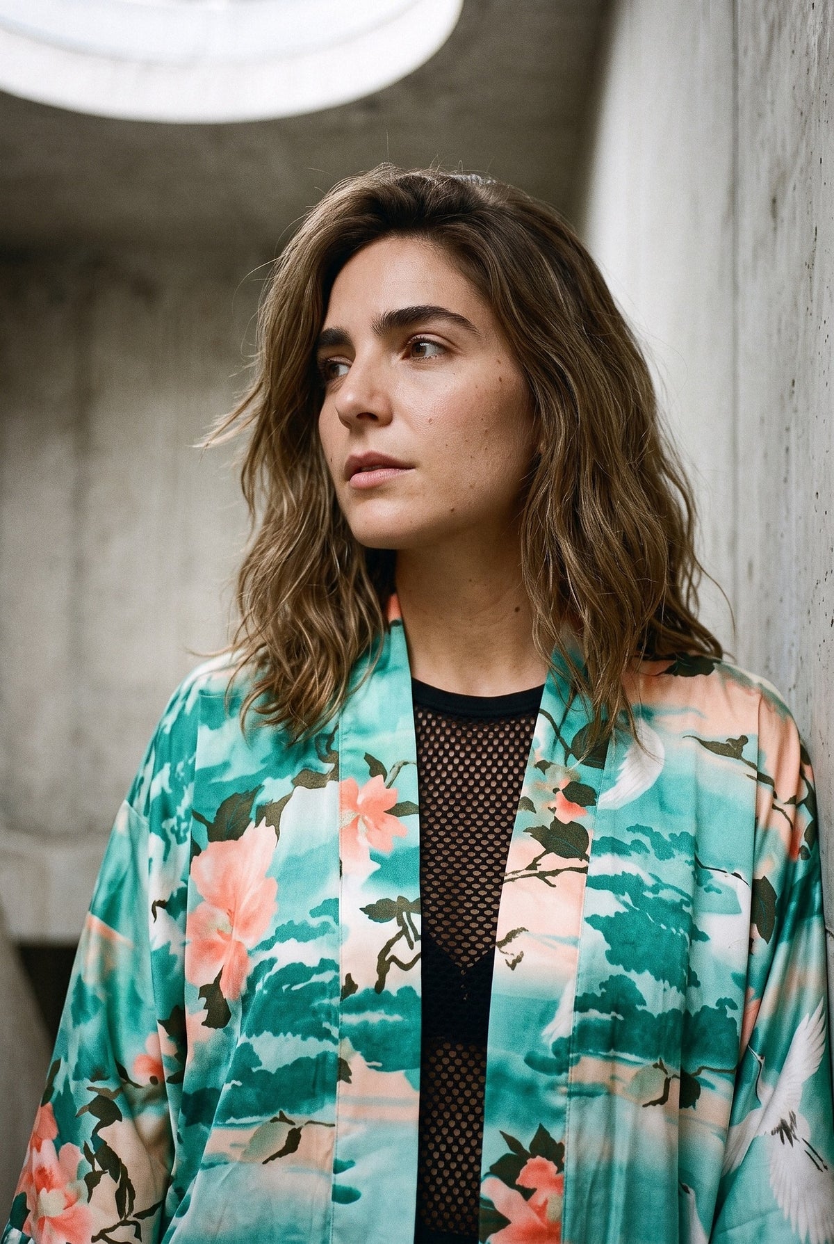 Kimono largo Natsu, grullas y paisaje japonés, turquesa: retrato con el cuello del kimono, en una escalera brutalista de hormigón en Madrid