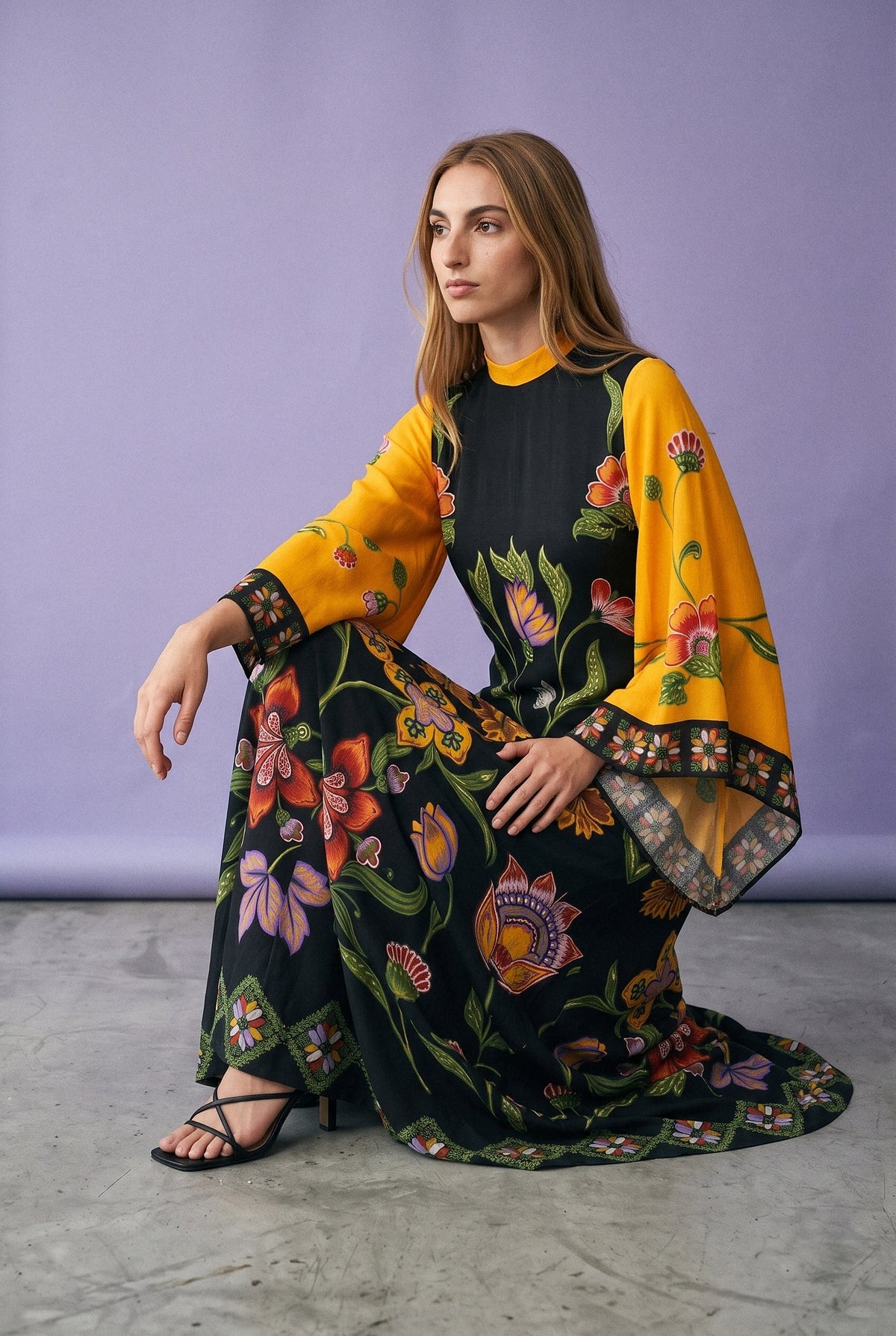 Vestido kimono Kogane, estampado negro y amarillo: modelo con una rodilla en el suelo, en estudio, fondo lila empolvado