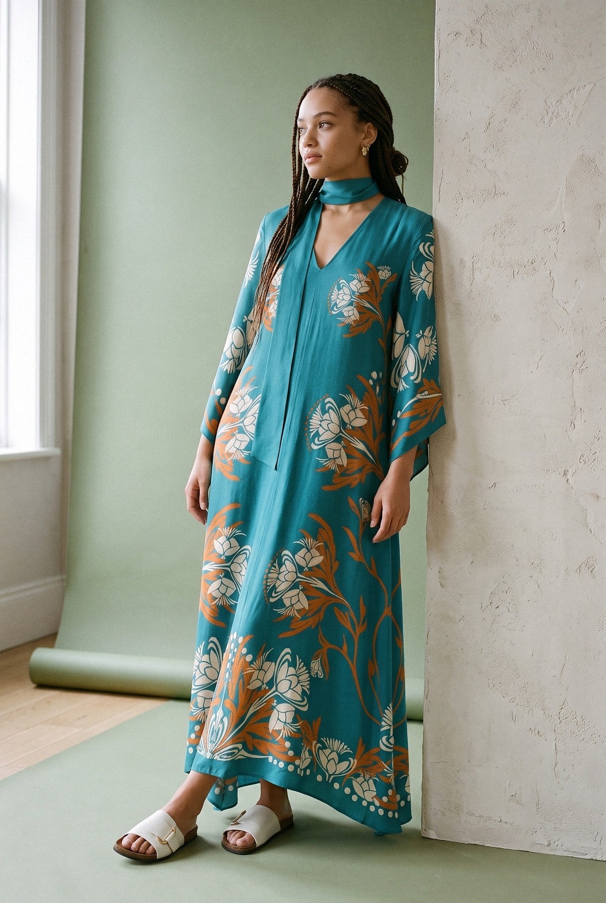 Vestido kimono Seiji, estampado turquesa: modelo apoyada en la pared, en estudio, fondo verde salvia